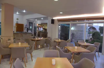 a restaurant with tables and chairs in a room at Barbie Hotel Apartments in Ialyssos