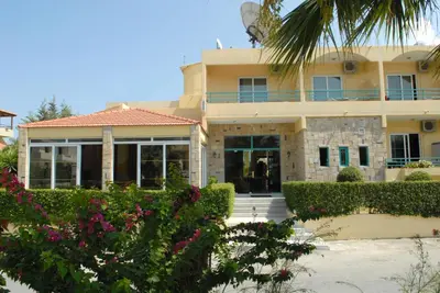 a house with a palm tree in front of it at Barbie Hotel Apartments in Ialyssos