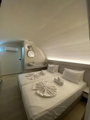 a bedroom with a bed with towels on it at Barbie Hotel Apartments in Ialyssos