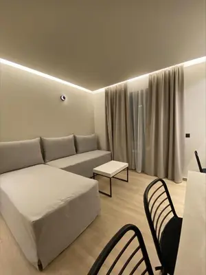 a living room with a bed and a table and chairs at Barbie Hotel Apartments in Ialyssos
