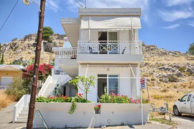 a white house with flowers in front of it at Haraki View in Haraki