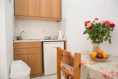 a kitchen with a table with a vase of flowers at Haraki View in Haraki