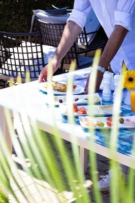 a man standing at a table with food on it at Grande Albergo Delle Rose in Rhodes Town