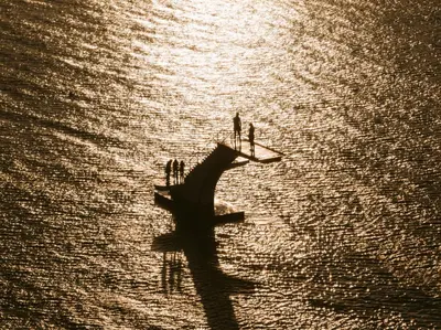 two people standing on a boat in the water at Grande Albergo Delle Rose in Rhodes Town