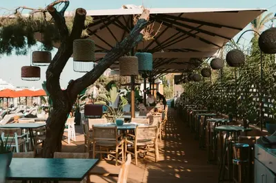 a restaurant with tables and chairs and umbrellas at Grande Albergo Delle Rose in Rhodes Town
