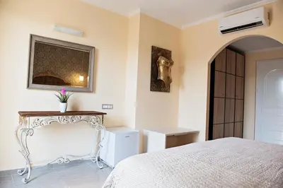 a bedroom with a bed and a table and a mirror at Hotel Kalithea in Kallithea Rhodes