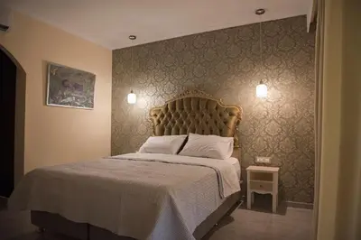 a bedroom with a large bed with a white bedspread at Hotel Kalithea in Kallithea Rhodes