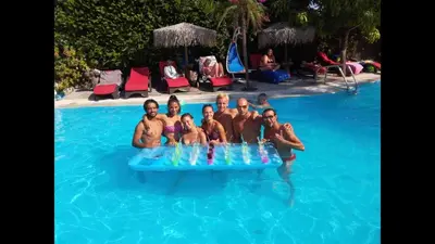 a group of people in a swimming pool with drinks at Hotel Kalithea in Kallithea Rhodes