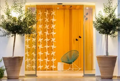 a room with a yellow door with two potted plants at Orion Hotel in Faliraki