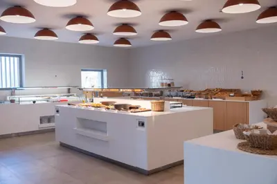 a large kitchen with white counters and lights on the ceiling at Orion Hotel in Faliraki