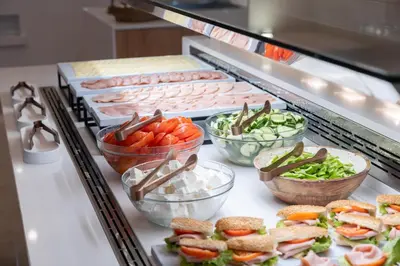 a buffet line with different types of vegetables and meats at Orion Hotel in Faliraki