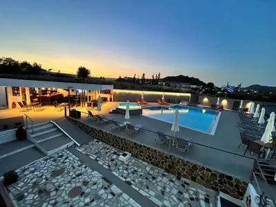 a large swimming pool with chairs and a building at Family House Faliraki Studios Apartments in Faliraki