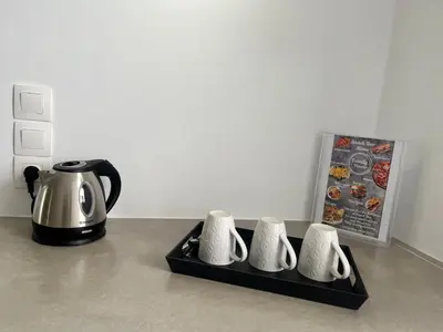 a tea kettle and four cups on a tray at Family House Faliraki Studios Apartments in Faliraki