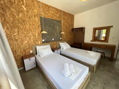 a room with two beds and a desk and a chalkboard at Family House Faliraki Studios Apartments in Faliraki