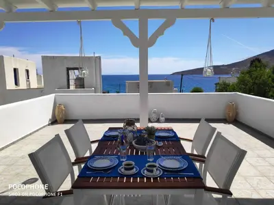 a wooden table with chairs and a blue table cloth at Estella’s House in Livadia