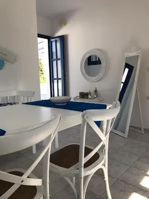 a white dining room with a white table and chairs at Estella’s House in Livadia