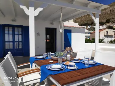 a table with a blue table cloth on a patio at Estella’s House in Livadia