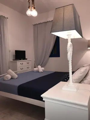 a bedroom with a bed with a lamp and a tv at Estella’s House in Livadia