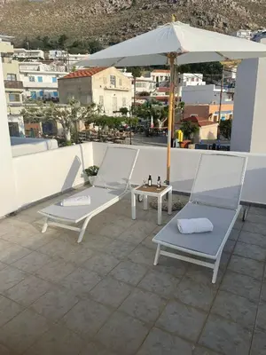 a patio with two chairs and an umbrella at Estella’s House in Livadia