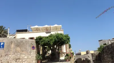 a white building with a tree in front of it at Minos Pension in Rhodes Town