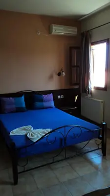 a blue bed in a bedroom with a window at Minos Pension in Rhodes Town