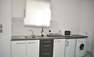 a kitchen with a sink and a washing machine at Levande Studio with private parking in Afantou
