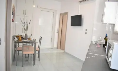 a kitchen and dining room with a table and a microwave at Levande Studio with private parking in Afantou