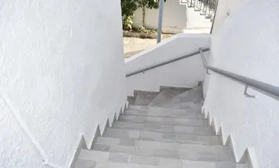 a staircase leading up to a white building at Levande Studio with private parking in Afantou