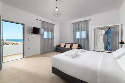 a white bedroom with a large bed and a couch at Ble Azzure in Gennadi