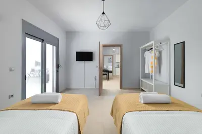 a white room with two beds and a television at Ble Azzure in Gennadi