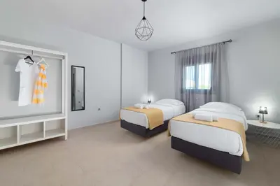 a hotel room with two beds and a tv at Ble Azzure in Gennadi