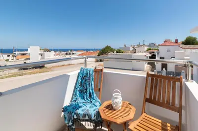 a balcony with two chairs and a table on a roof at Ble Azzure in Gennadi