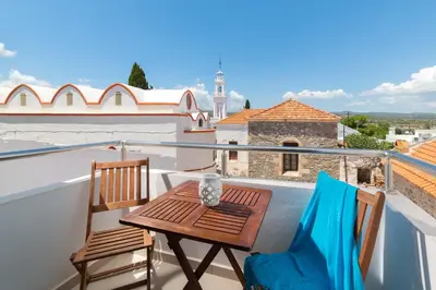 a balcony with a wooden table and two chairs at Ble Azzure in Gennadi
