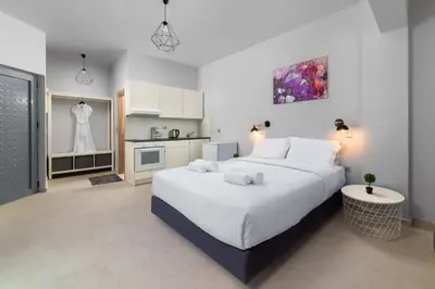 a bedroom with a large white bed and a kitchen at Ble Azzure in Gennadi