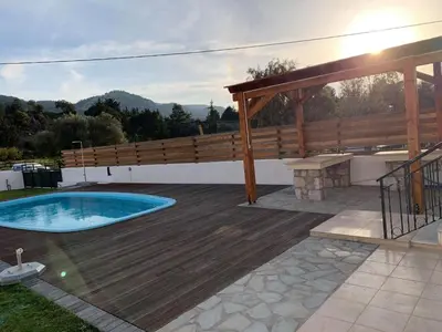 a patio with a wooden deck and a swimming pool at Butterfly Estates Maritsa Rhodes in Pastida