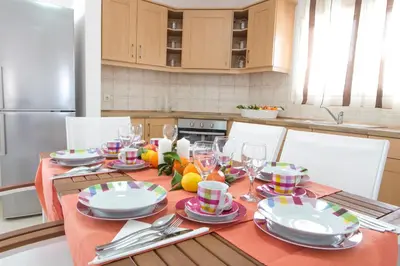 a kitchen with a table with plates and wine glasses at Butterfly Estates Maritsa Rhodes in Pastida