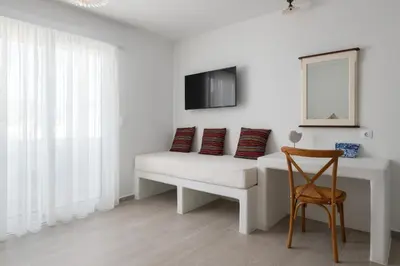 a white room with a couch and a chair at Stegna Akti Luxury Suites in Archangelos