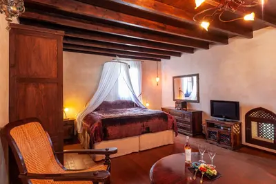a bedroom with a bed and a table and a tv at Spirit Of The Knights Boutique Hotel in Rhodes Town