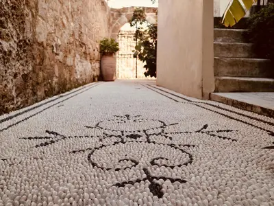 a cobblestone street with a flower design on the ground at Spirit Of The Knights Boutique Hotel in Rhodes Town