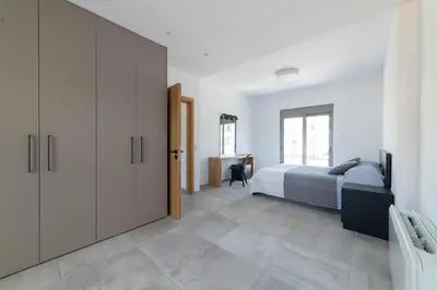 a bedroom with a bed and a desk at Aegean Treasure Pefkos in Pefki Rhodes