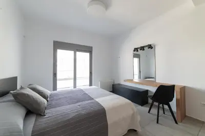 a bedroom with a bed and a desk and a chair at Aegean Treasure Pefkos in Pefki Rhodes