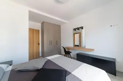 a bedroom with a large bed and a desk at Aegean Treasure Pefkos in Pefki Rhodes