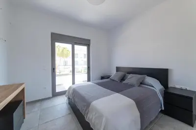 a bedroom with a large bed and a window at Aegean Treasure Pefkos in Pefki Rhodes