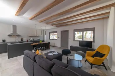 a living room with a couch and a kitchen at Aegean Treasure Pefkos in Pefki Rhodes