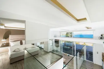 a living room with white walls and a glass floor at Lindian Jewel Hotel and Villas in Líndos