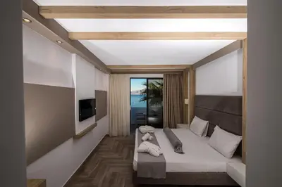 a bedroom with a bed with a teddy bear on it at Lindian Jewel Hotel and Villas in Líndos