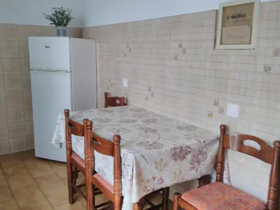 a kitchen with a table and a refrigerator at Maria Studios and Apartments in Haraki