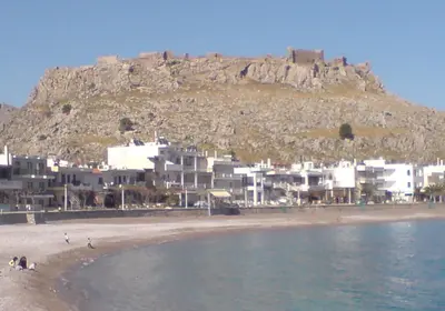 a view of a beach with a mountain in the background at Maria Studios and Apartments in Haraki