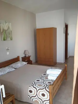 a bedroom with a bed and a wooden cabinet at Maria Studios and Apartments in Haraki