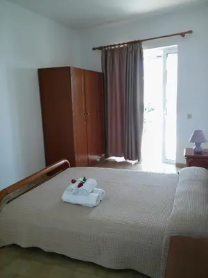 a bedroom with a bed with a towel on it at Maria Studios and Apartments in Haraki